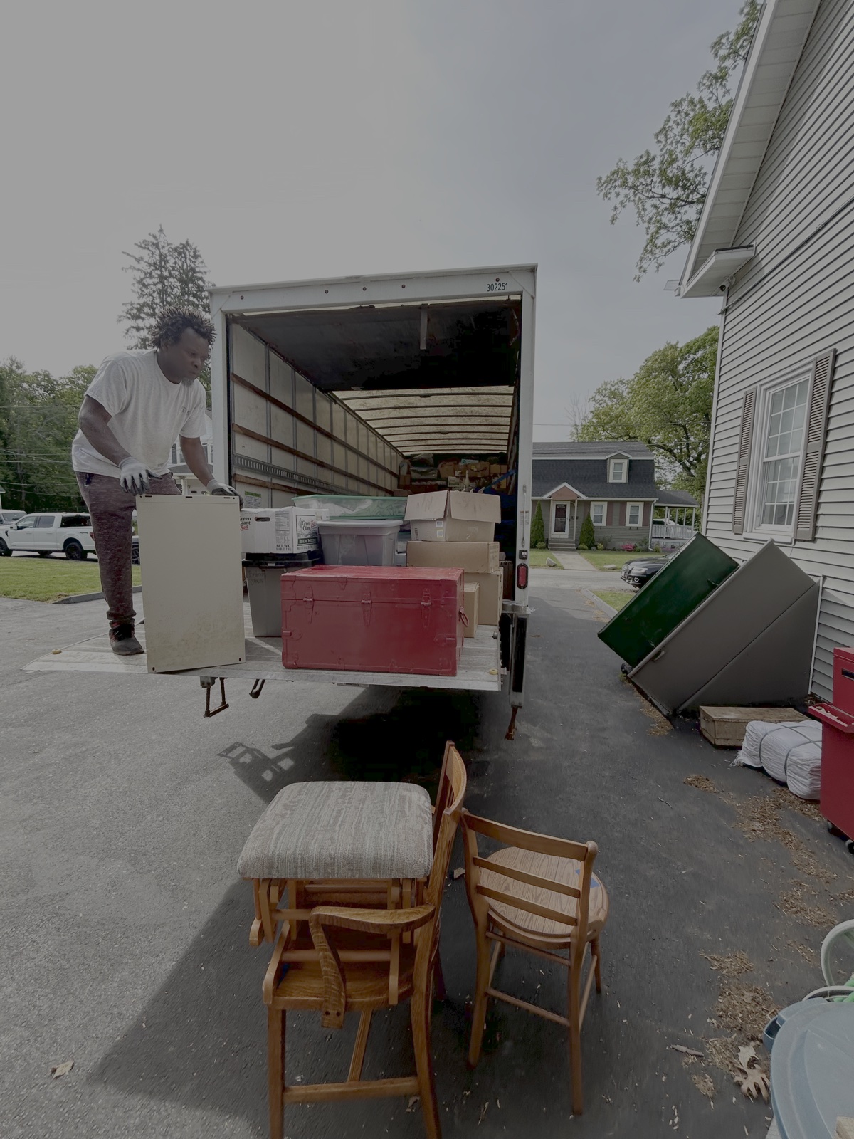 Household items being loaded into a truck beside a home