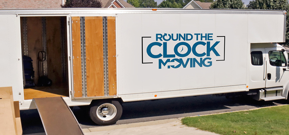 Round The Clock Moving truck parked beside a home